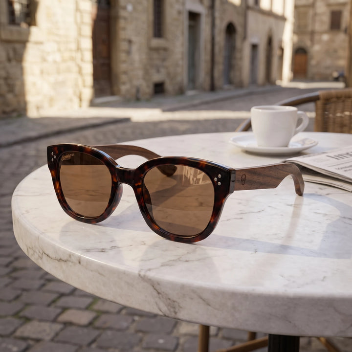 Lentes de sol Bonoboss Tren Tren Carey sobre mesa de mármol en terraza de café #editorial_grid1 #color_carey