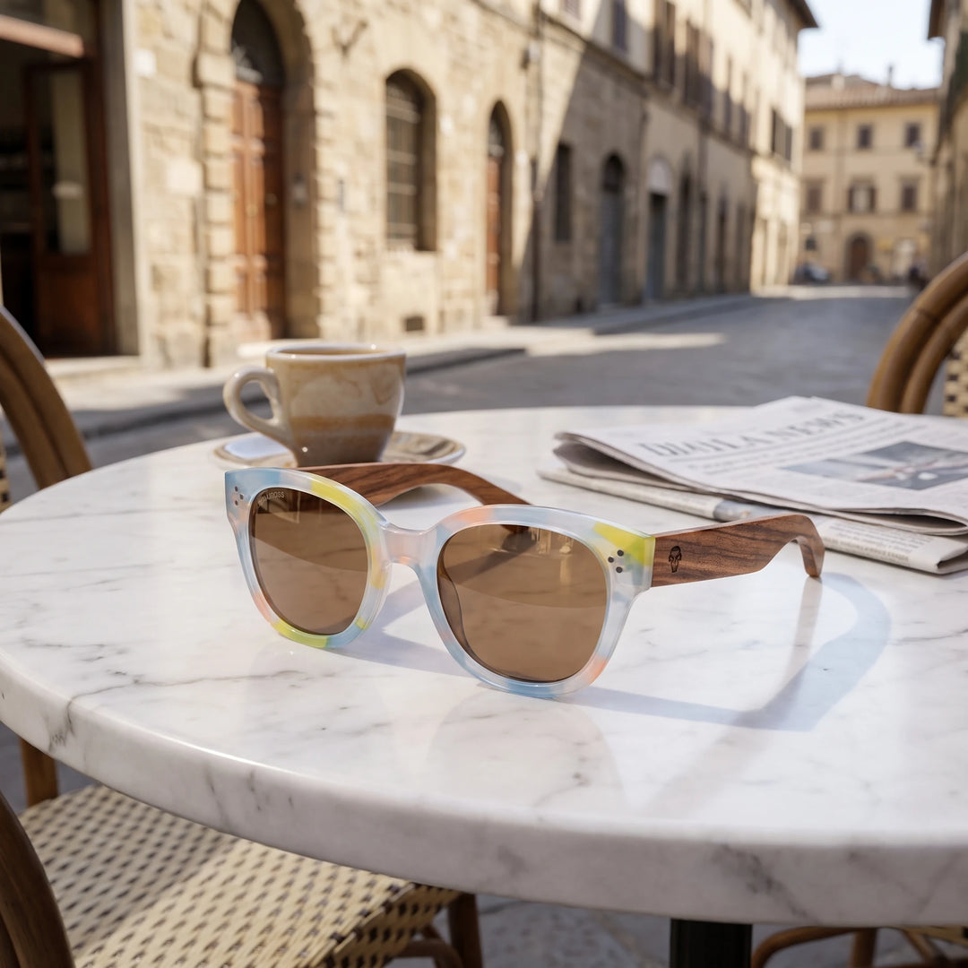 Lentes de sol Bonoboss Tren Tren Yellow sobre mesa de mármol en terraza de café #editorial_grid1 #color_yellow
