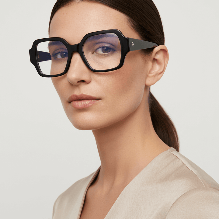 vista lateral de una mujer de cara ovalada de ojos color cafe y pelo tomado de color castaño usando unos armazones anteojos marcos opticos Bonoboss en acetato biodegradable reciclado sustentable de tamaño XL extra grandes oversized de #color_negro