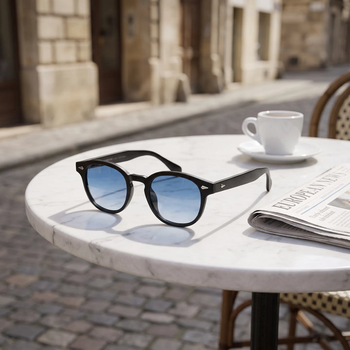 Lentes de sol Bonoboss Waimea RPET Gradiente Azul sobre mesa de mármol en terraza de café #editorial_grid1 #color_gradiente-azul