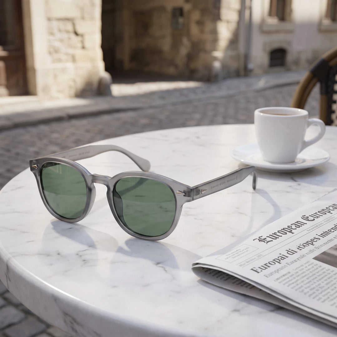 Lentes de sol Bonoboss Waimea RPET Transparente G15 sobre mesa de mármol en terraza de café #editorial_grid1 #color_transparente-g15